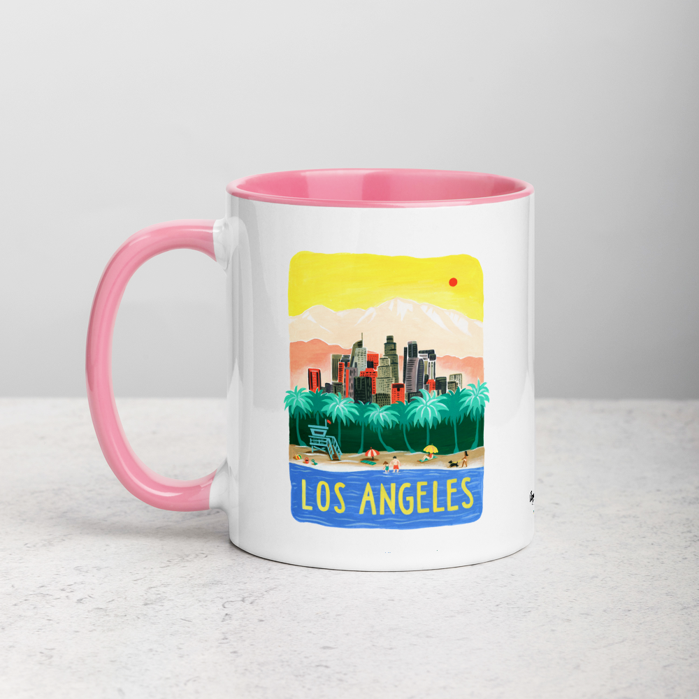White ceramic coffee mug with pink handle and inside; has Los Angeles California illustration by Angela Staehling
