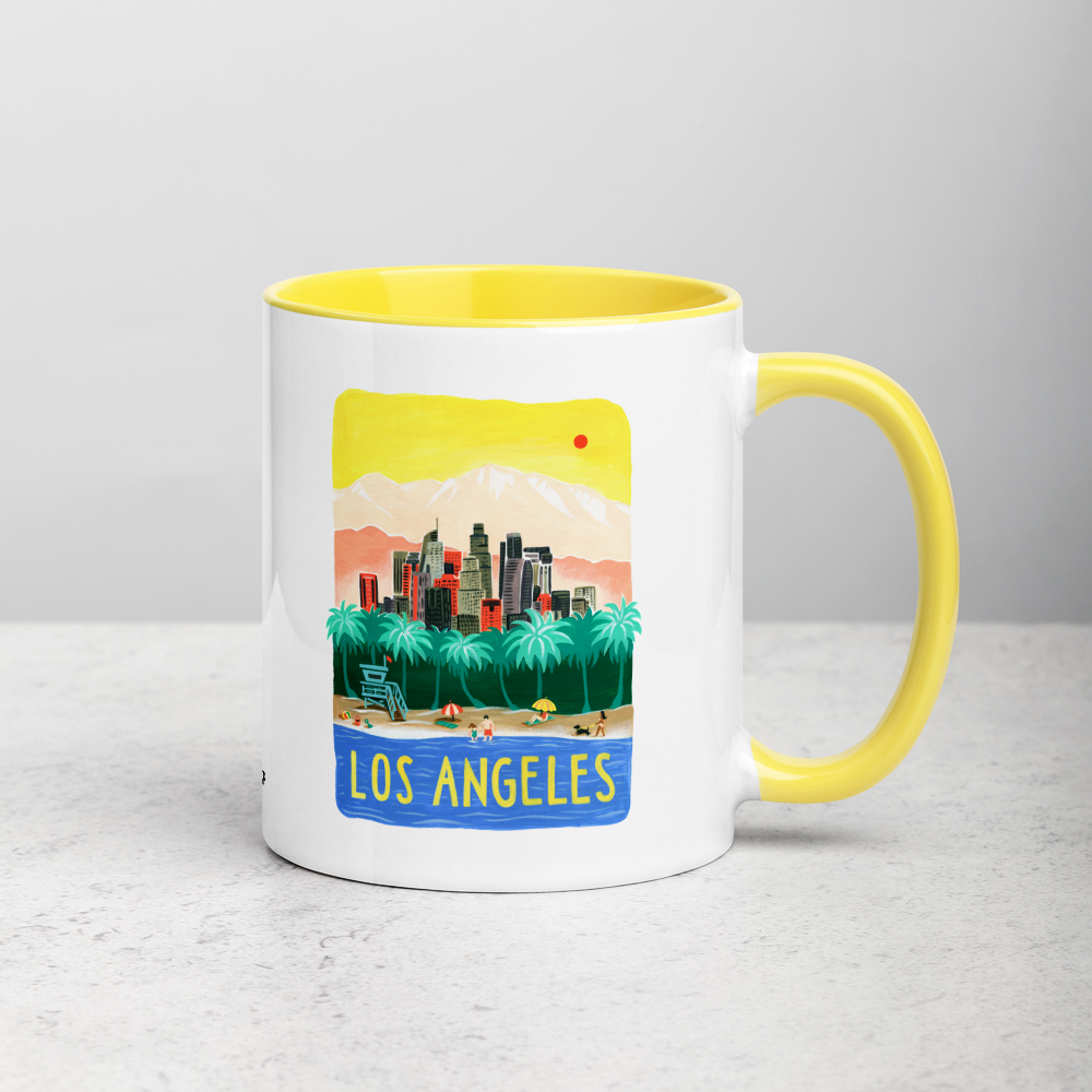 White ceramic coffee mug with yellow handle and inside; has Los Angeles California illustration by Angela Staehling