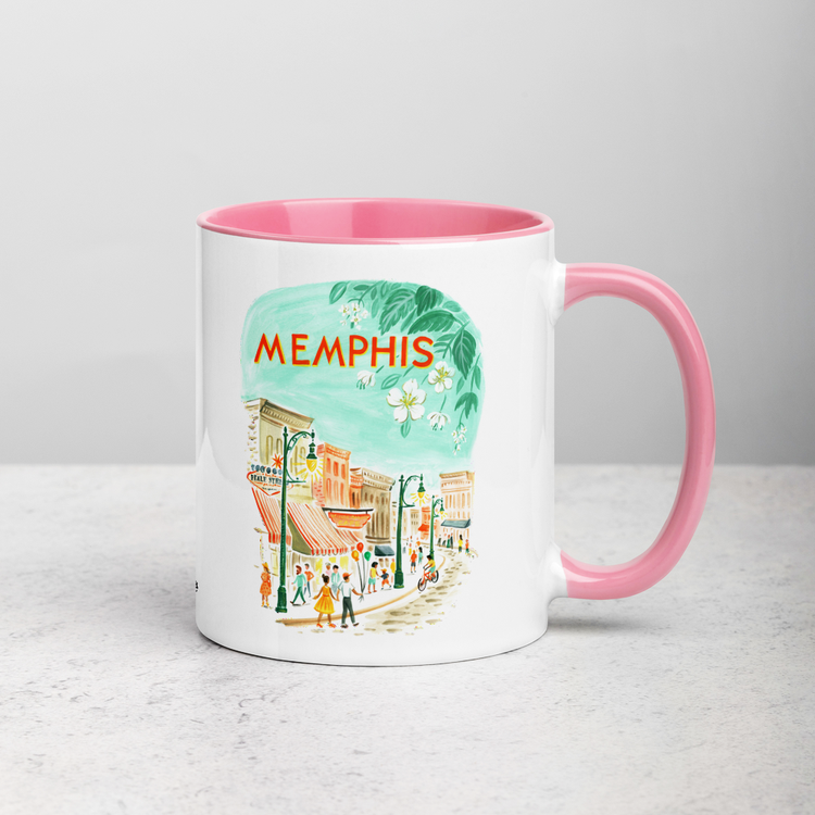 White ceramic coffee mug with pink handle and inside; has Memphis Tennessee illustration by Angela Staehling