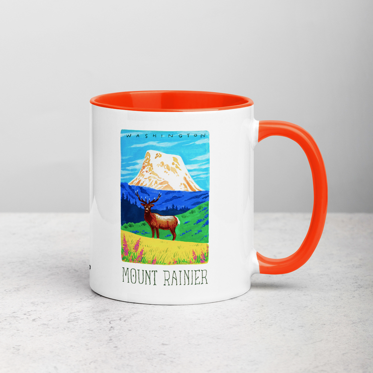 White ceramic coffee mug with orange handle and inside; has Mount Rainier National Park illustration by Angela Staehling
