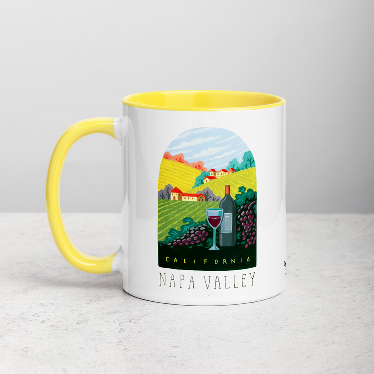 White ceramic coffee mug with yellow handle and inside; has Napa Valley California illustration by Angela Staehling