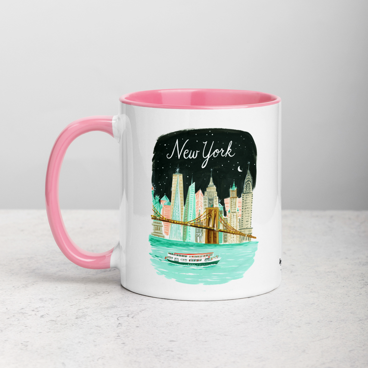 White ceramic coffee mug with pink handle and inside; has New York City Skyline illustration by Angela Staehling