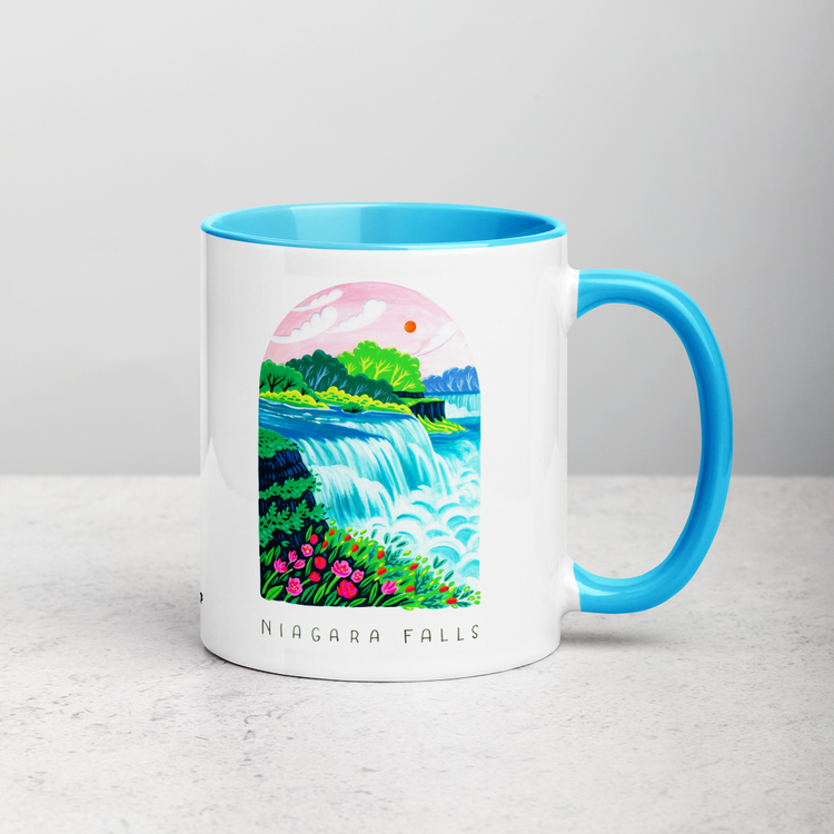 White ceramic coffee mug with blue handle and inside; has Niagara Falls National Park illustration by Angela Staehling