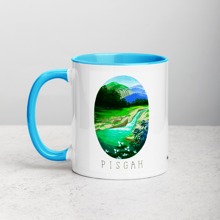 White ceramic coffee mug with blue handle and inside; has Pisgah National Park illustration by Angela Staehling