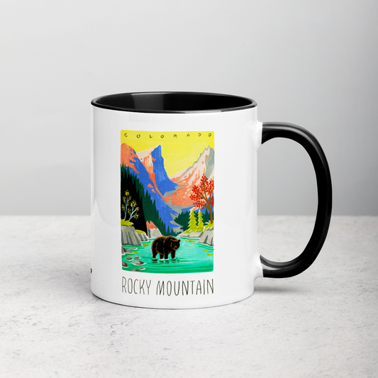 White ceramic coffee mug with black handle and inside; has Rocky Mountain National Park illustration by Angela Staehling