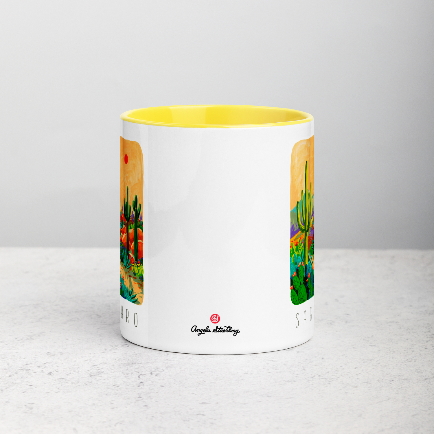 White ceramic coffee mug with yellow handle and inside; has Saguaro National Park illustration by Angela Staehling
