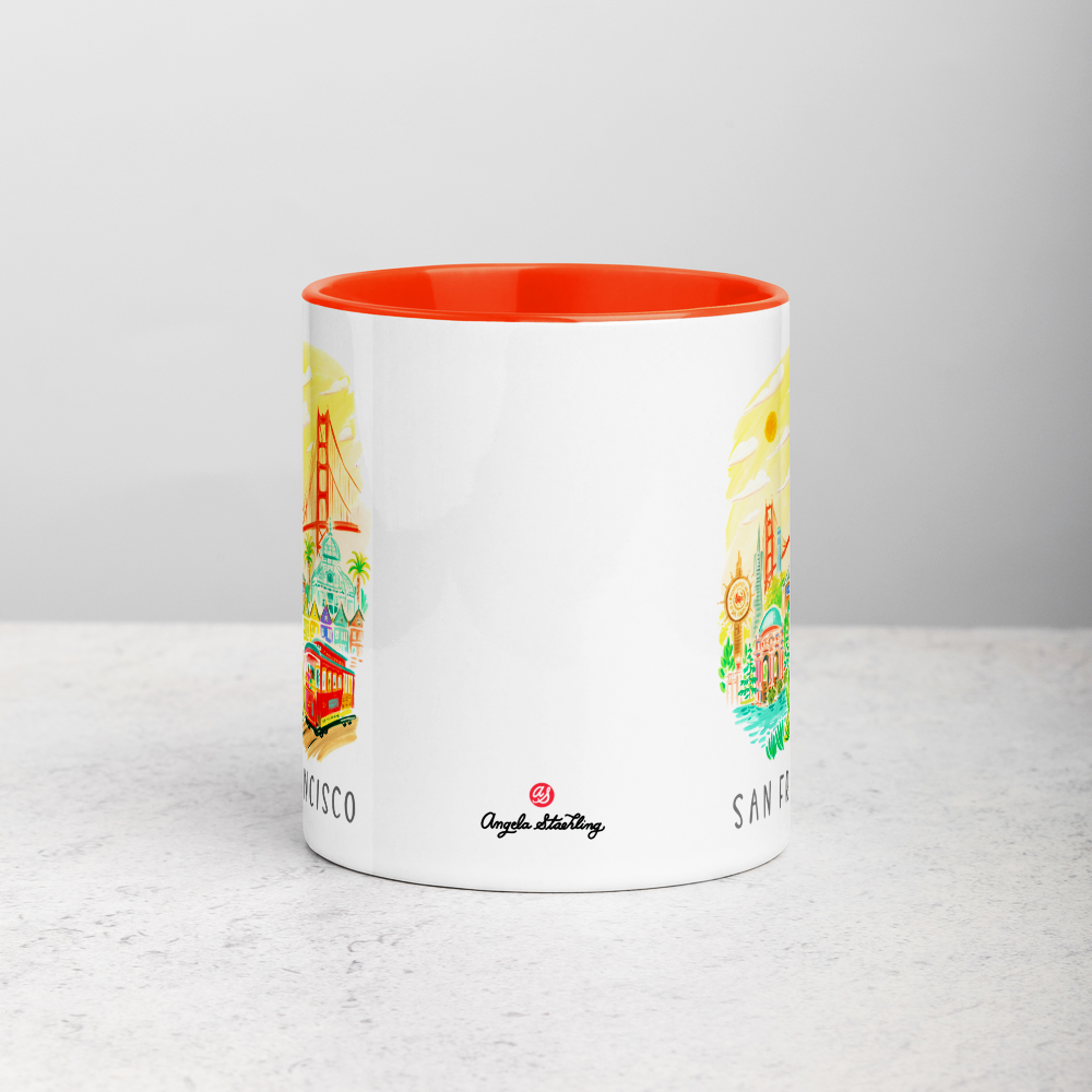 White ceramic coffee mug with orange handle and inside; has San Francisco Golden Gate illustration by Angela Staehling