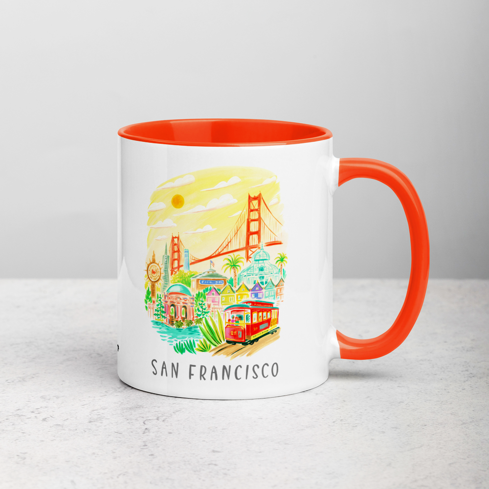 White ceramic coffee mug with orange handle and inside; has San Francisco Golden Gate illustration by Angela Staehling