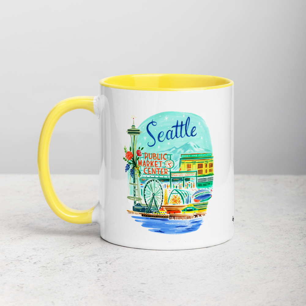 White ceramic coffee mug with yellow handle and inside; has Seattle Washington illustration by Angela Staehling