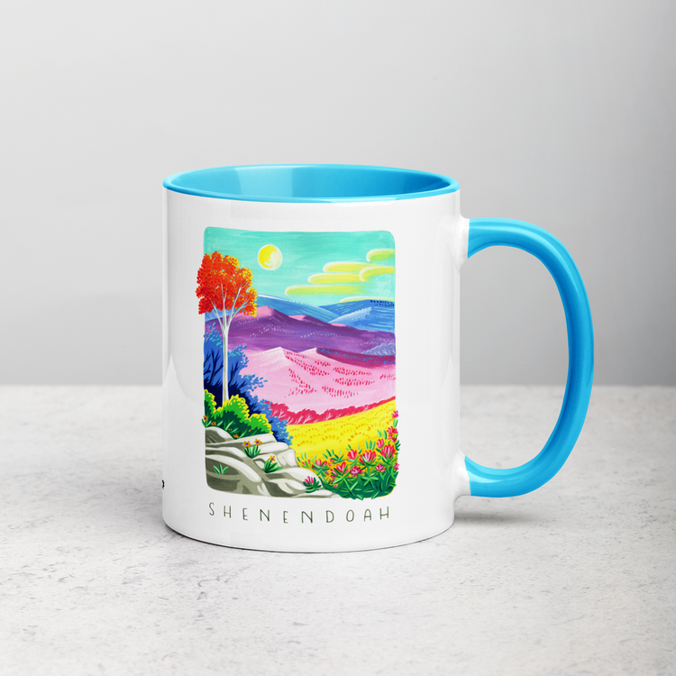 White ceramic coffee mug with blue handle and inside; has Shenandoah National Park illustration by Angela Staehling