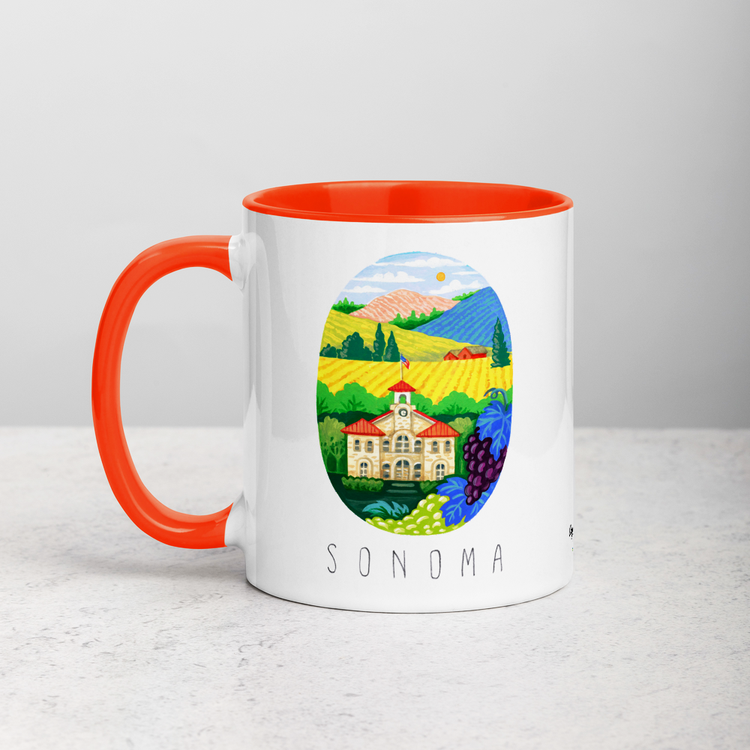 White ceramic coffee mug with orange handle and inside; has Sonoma Valley California illustration by Angela Staehling