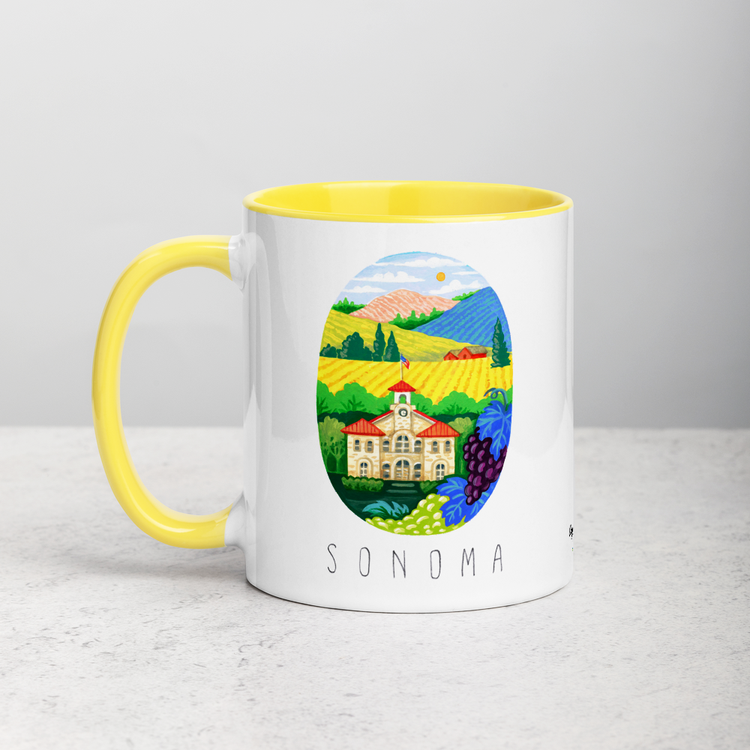 White ceramic coffee mug with yellow handle and inside; has Sonoma Valley California illustration by Angela Staehling