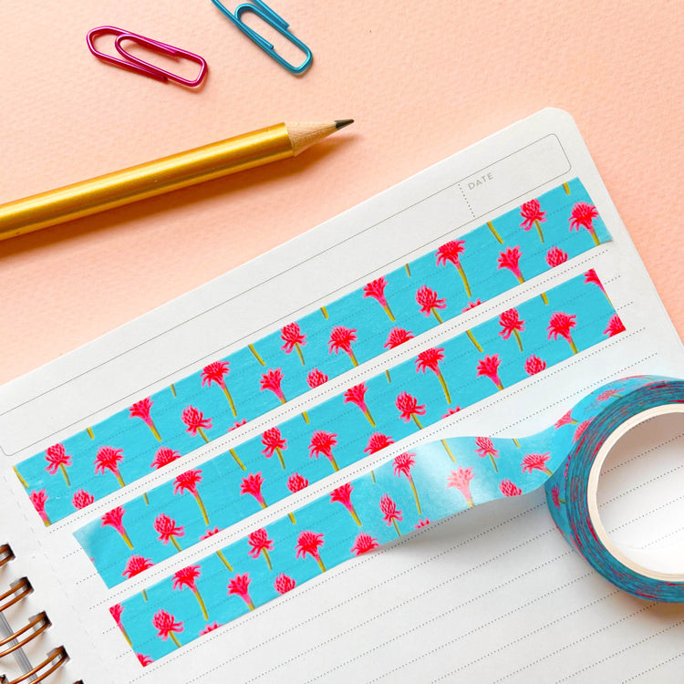 Three rows of light blue tropical washi tape with pencil and paperclips