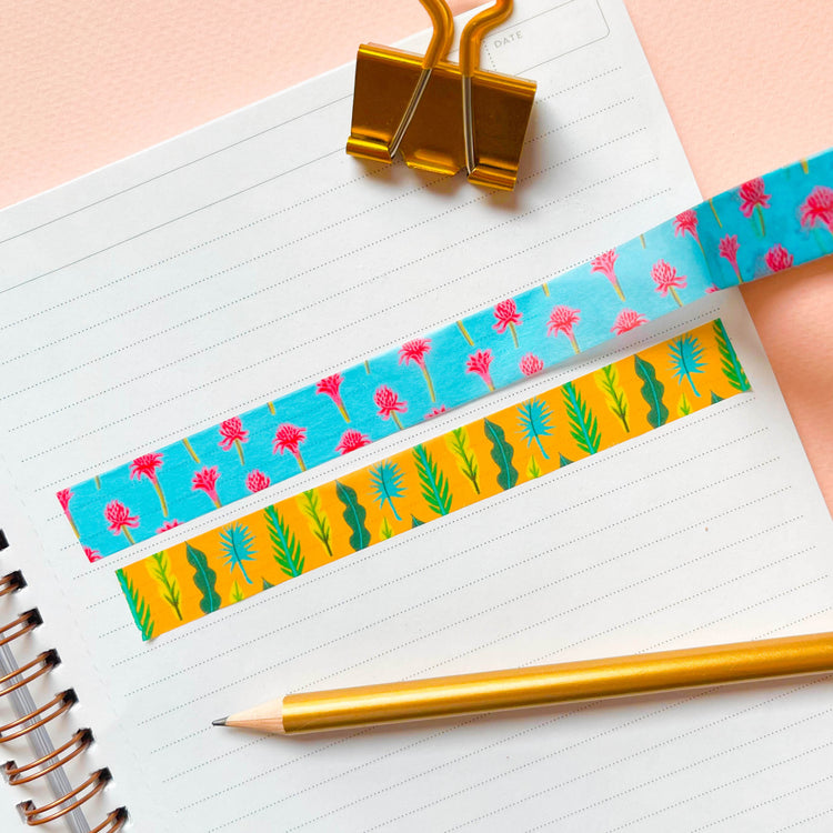 Tropical light blue washi tape with magenta flowers next to a golden leaf pattern washi tape