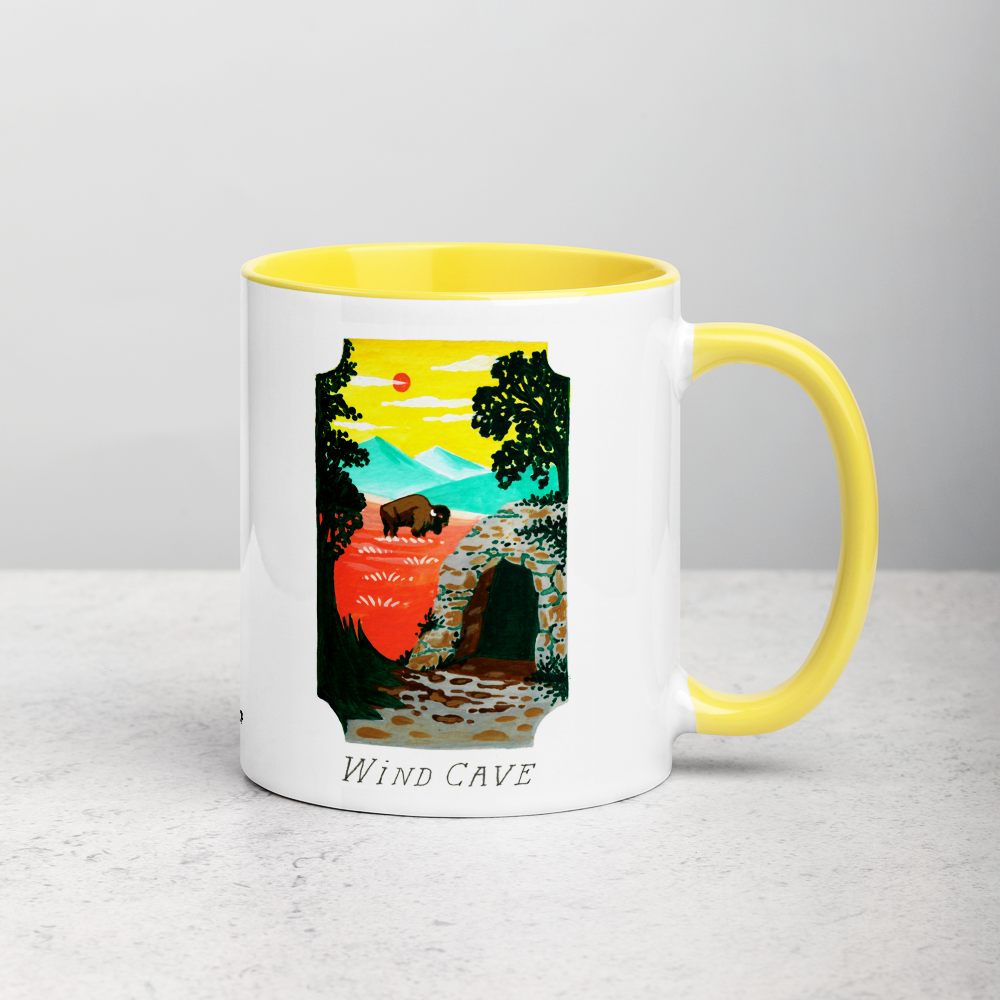 White ceramic coffee mug with yellow handle and inside; has Wind Cave National Park illustration by Angela Staehling